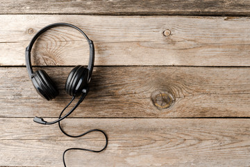 Headphones on wooden background. Call center concept