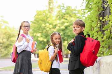 Cute little pupils after classes outdoors
