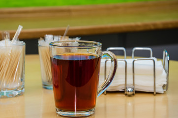 cup of tea on a background of a wooden table, wooden sticks and napkins. Close-up.