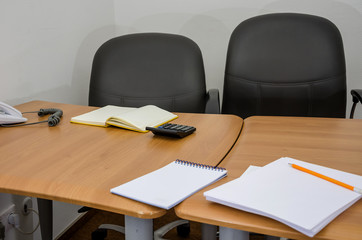 office table with a chair, calculator, notebook, stationery.