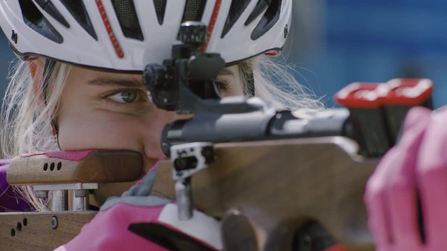 EXTREME CU Portrait of Caucasian female professional biathlete practicing on a shooting range during mid-season practice in summer. ARRI Alexa Mini with Cooke S4 prime lenses RAW graded footage