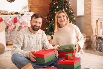 Obraz na płótnie Canvas Happy couple with Christmas gifts at home