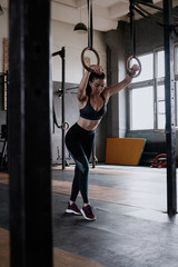Fototapeta premium Happy healthy athletic woman laughing, resting after gymnastic rings workout