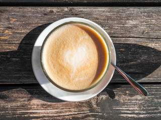 Glass cup of coffee latte on wooden table