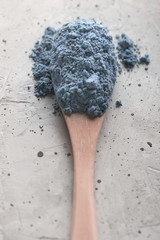 Blue tea matcha in a spoon on concrete surface. Close up shot