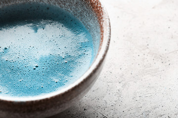 Blue tea matcha in a bowls and chasen on concrete surface