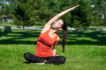 Yoga. Young woman practicing yoga meditation in nature a park. Health lifestyle concept