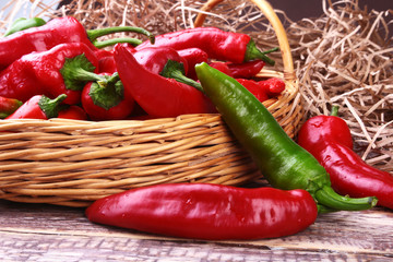 Wicker basket full of fresh red chili peppers.