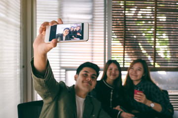 Group of businesspeople using mobile phone to take a selfie together
