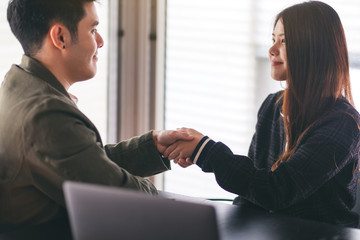 Closeup image of two businesspeople shaking hands in a meeting