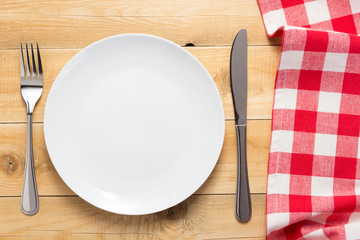 plate, knife and fork at wooden  table background