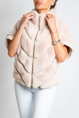 Womens fur jacket, short sleeve, with a light pink tint.