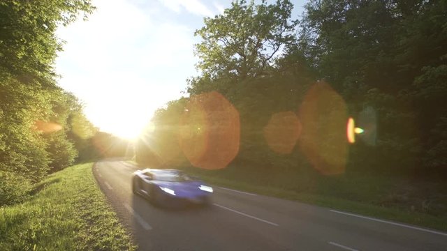 Blue sports car driving in the countryside