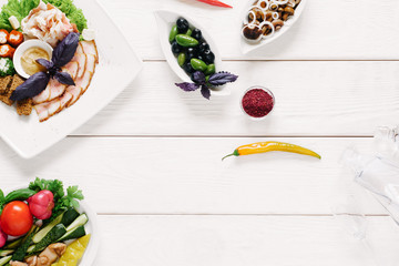 Vodka snacks assortment. Meat and vegetable appetizers, spices and glass decanter on white wooden...