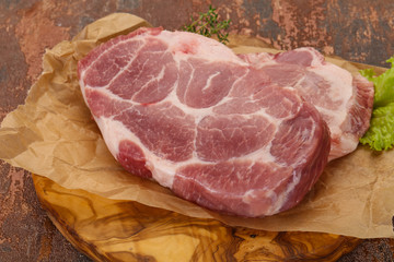 Raw pork steak over wooden board