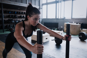 Fit female athlete working out in the gym. Crossfit woman exercising