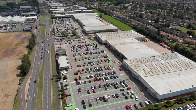 Aerial footage of the Wheatley Shopping Centre located in the heart of Doncaster in Yorkshire, typical British shopping complex and car park with cars parking.
