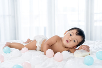 Obraz na płótnie Canvas cheerful baby lying on bed