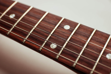 Guitar neck and strings close up top view on white background.