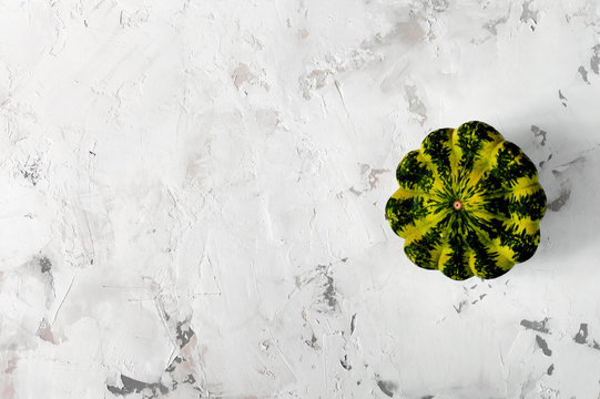 Squash or patison on a light concrete texture background, copy space