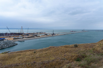 The shore of the Kerch Strait during the construction of the Kerch Bridge in cloudy weather with clouds in the sky.