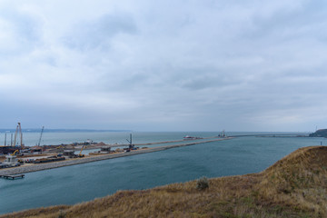 The shore of the Kerch Strait during the construction of the Kerch Bridge in cloudy weather with clouds in the sky.