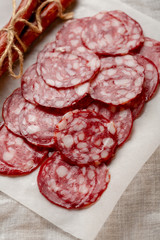 Sliced smocked salami on white pepper