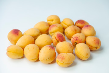 Ripe fresh apricots on a white background, top view, space for text
