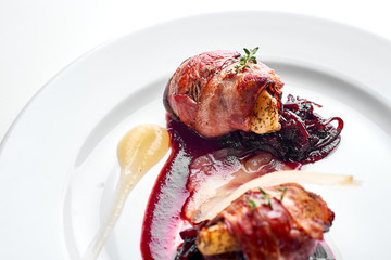  Chicken wrapped in bacon on a white plate