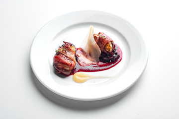  Chicken wrapped in bacon on a white plate