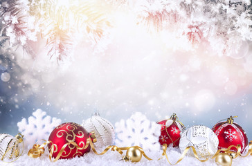 Christmas decoration with red and white Christmas balls, snowflakes in snow and snow covered fir...