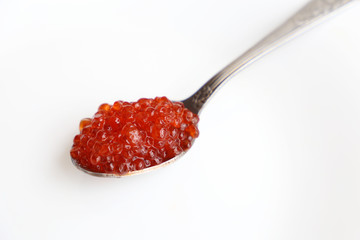 Red caviar in a spoon closeup on white background