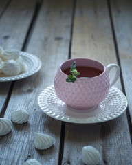 Light lunch with tea and cookies in elegant ceramic dishes and a teaspoon, the composition on the rustic Board unpainted table, horizontal frame