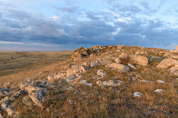 Dawn on a mountain in the steppe of the Opuksky nature reserve with yellow grass, with clouds on the sky, shot during the season of golden autumn. Yellow-golden brown.