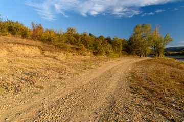 view of the mountain green valley surrounded by dense vegetation of green trees on a sunny day with clouds in the sky, from the observation deck.