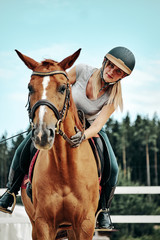 Obraz premium young girl rider in equipment on horseback. Horseback Riding.