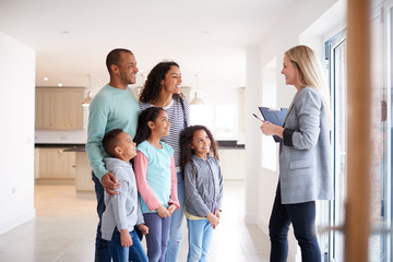 Fototapeta premium Female Realtor Showing Family Interested In Buying Around House