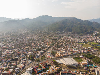 Aerial photos of the beautiful beach and town of Puerto Vallarta in Mexico, the town is on the Pacific coast in the state known as Jalisco with the mountains in the background on a cloudy day.