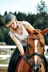 Foto op Canvas young girl rider in equipment on horseback. Horseback Riding. © Olek