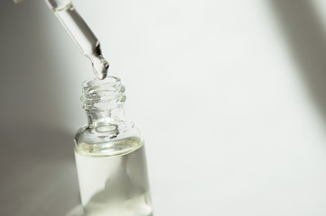 Cosmetic or medical glass bottle with pipette on white background. Skin care concept. Natural hard...