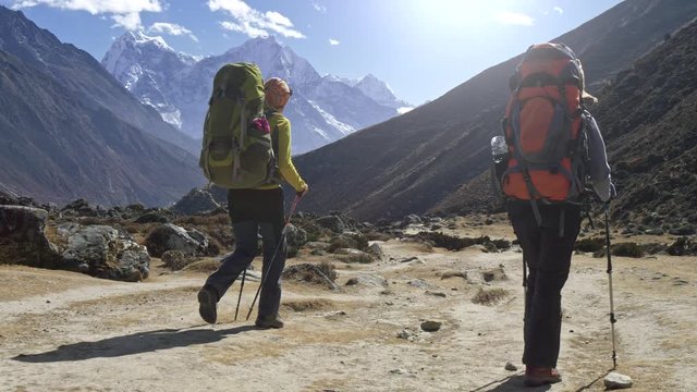 Two tourists on the way to Everest base camp in Himalayas, Nepal. Gimbal, slow motion shot