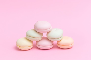 Delicate colored marshmallows on a pink background minimal style. Copy space