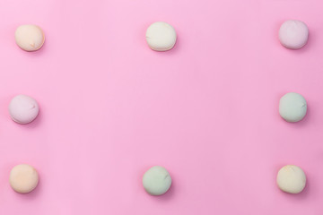 Delicate colored marshmallows on a pink background minimal style. Top view. Copy space