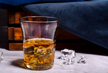 Whiskey or Cognac in the Glass With the Ice. Alcohol drink against dark background.