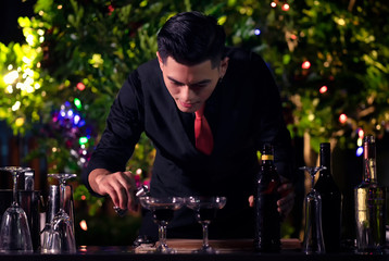 High ISO.The bartender with a cocktail is preparing a cocktail at the bar. Alcoholic beverages, people and luxury concepts.barman making cocktail at nightclub