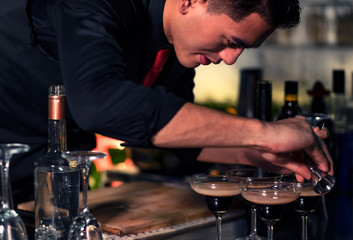 High ISO.The bartender with a cocktail is preparing a cocktail at the bar. Alcoholic beverages, people and luxury concepts.barman making cocktail at nightclub