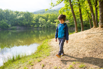 A boy with a backpack on the lake.