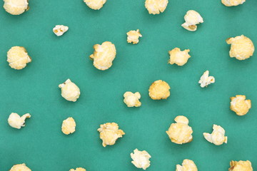 Top view of salted popcorn mix with cheese popcorn spilled on green background