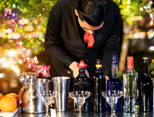 High ISO.The bartender with a cocktail is preparing a cocktail at the bar. Alcoholic beverages, people and luxury concepts.barman making cocktail at nightclub