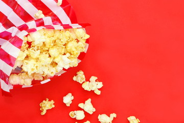 Top view isolated salted popcorn mix with cheese popcorn spilled from striped bag (red and white...